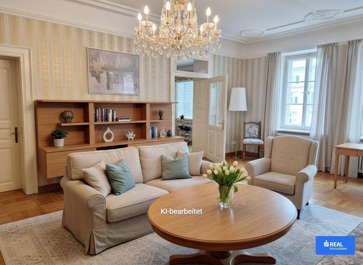 Modernisierte Wohnzimmereinrichtung mit hellem Sofa, Holztisch und schlichten Regalen unter einem Kronleuchter.