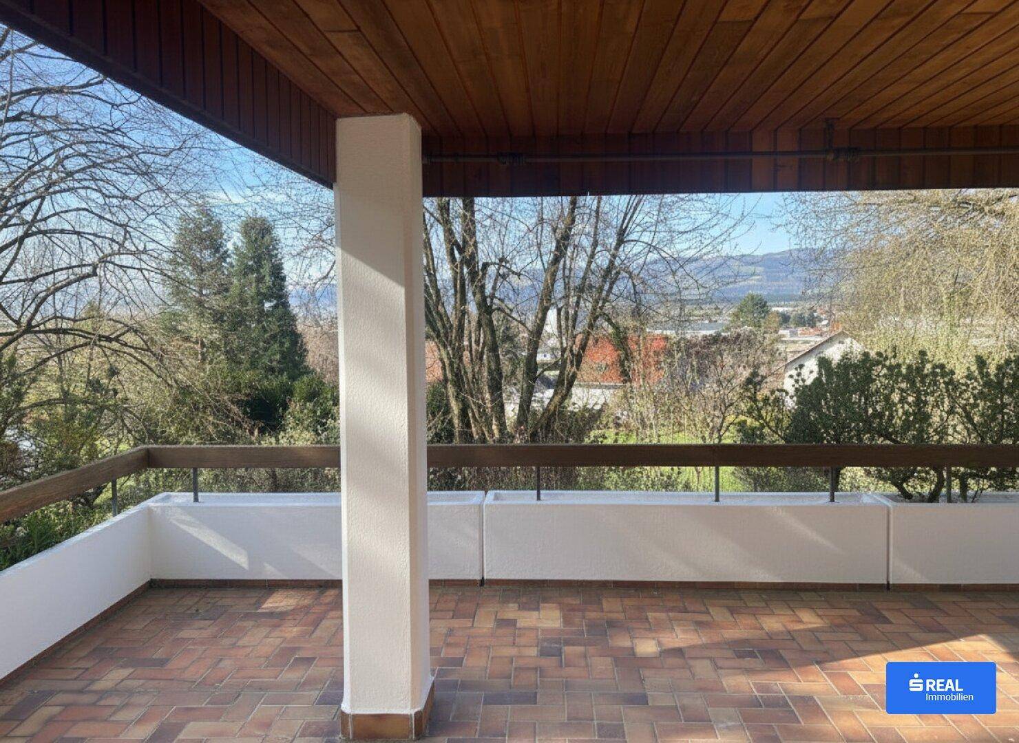 Großer Balkon mit weitem Blick auf die umliegende Landschaft und die Berge.
