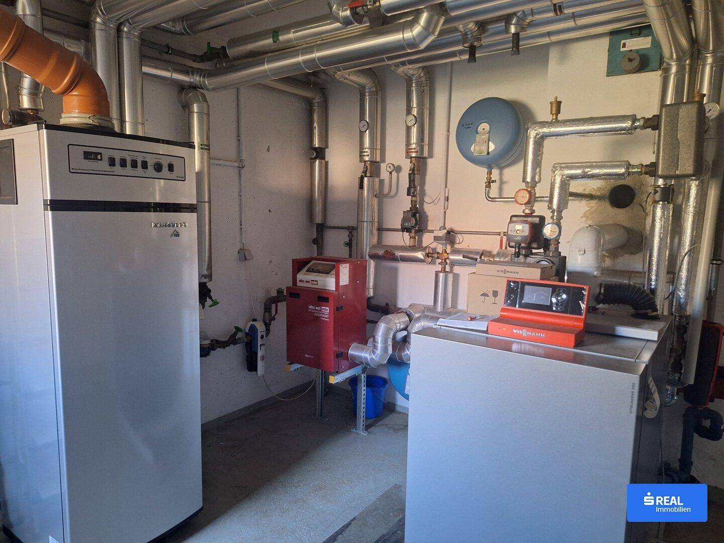 Heizungsraum mit moderner Heizungsanlage und Warmwasserspeicher.