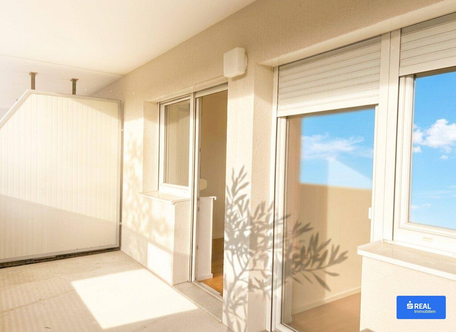 Sonniger Balkon mit Schiebetüren und Rollläden, ideal für entspannte Stunden im Freien.