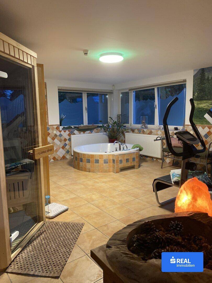 Wellnessbereich mit Whirlpool, Sauna und Fitnessgeräten für Entspannung und Training.