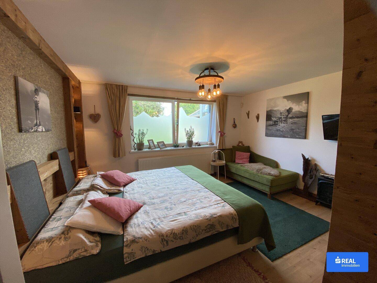 Komfortables Schlafzimmer mit großem Bett, Holzbalken und Blick auf die Umgebung.