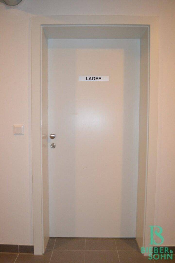 Weiße Tür mit der Aufschrift "LAGER" in einem Flur, deutet auf einen Abstellraum hin.