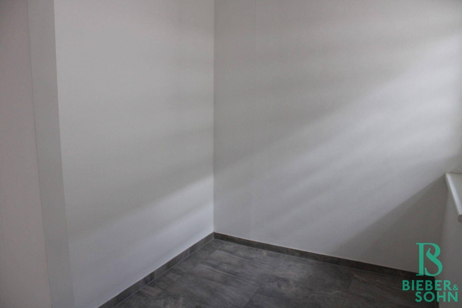 Kleiner, leerer Raum mit Fliesenboden und weißen Wänden, vielseitig nutzbar.