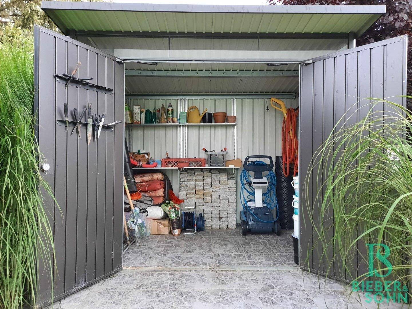 Innenansicht des Gartenhauses mit Regalen, Werkzeugen und Gartengeräten.
