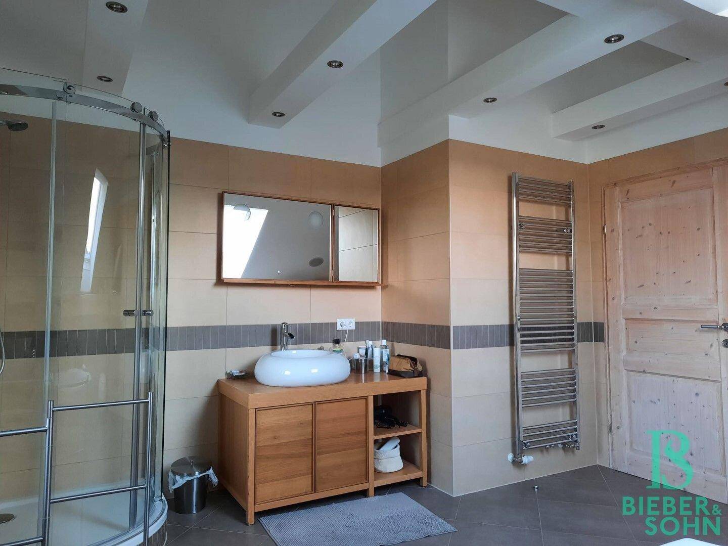 Modernes Badezimmer mit runder Duschkabine, Waschbecken und beheiztem Handtuchhalter.