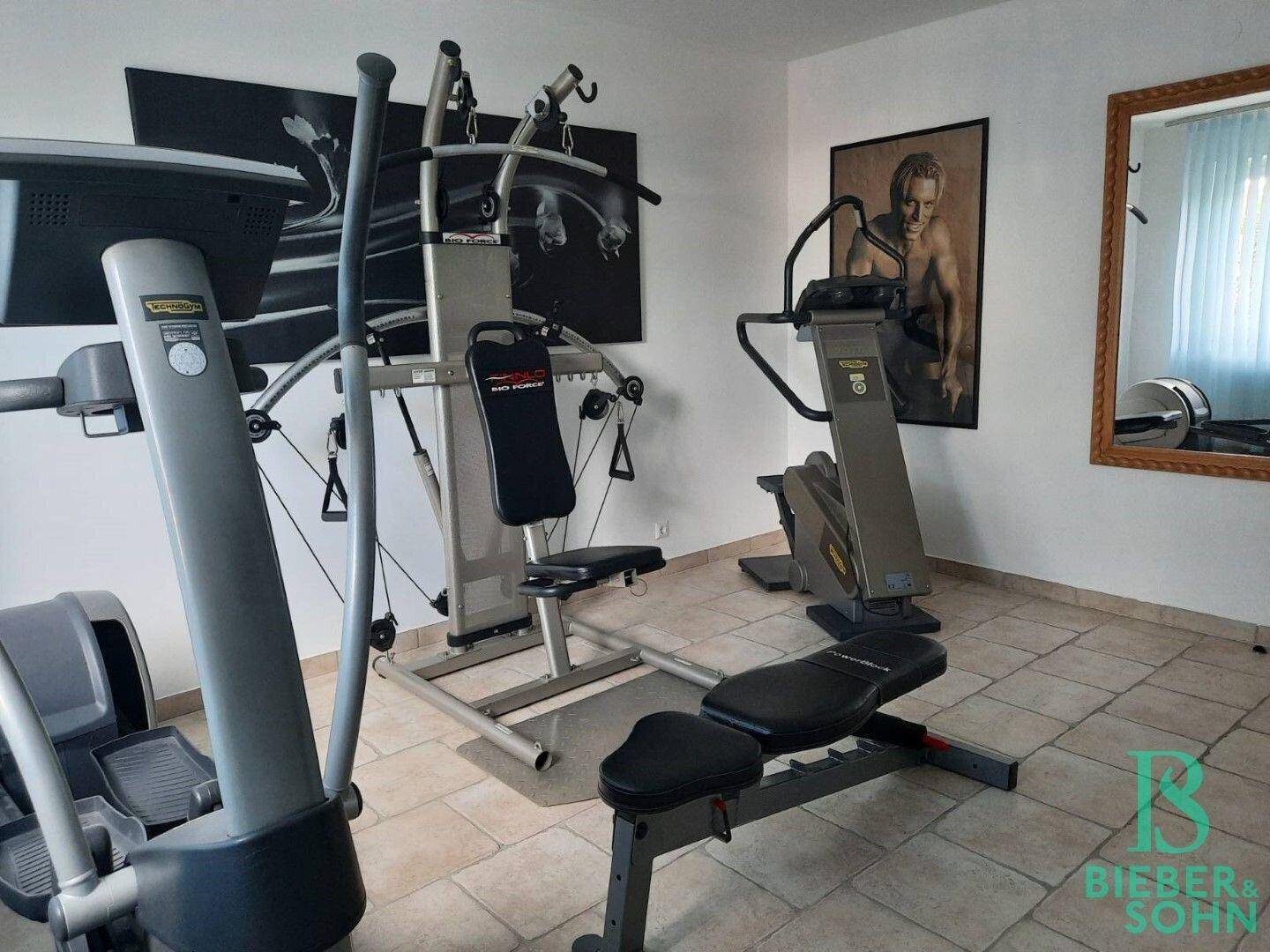 Fitnessraum mit verschiedenen Trainingsgeräten und Fliesenboden für sportliche Aktivitäten.
