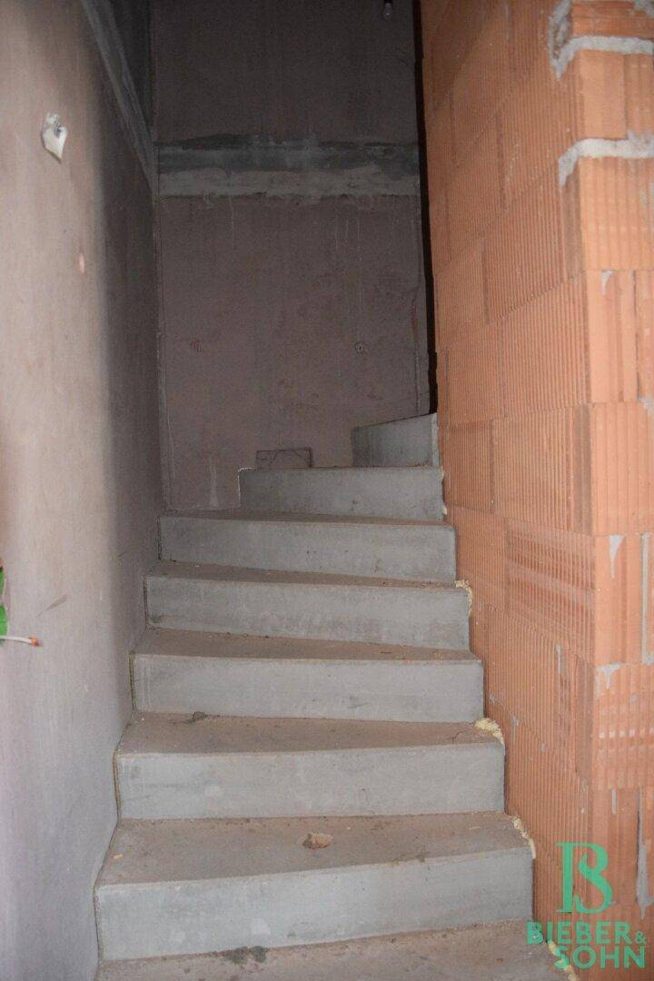Unfertige Betontreppe im Rohbau, die die Stockwerke verbindet.