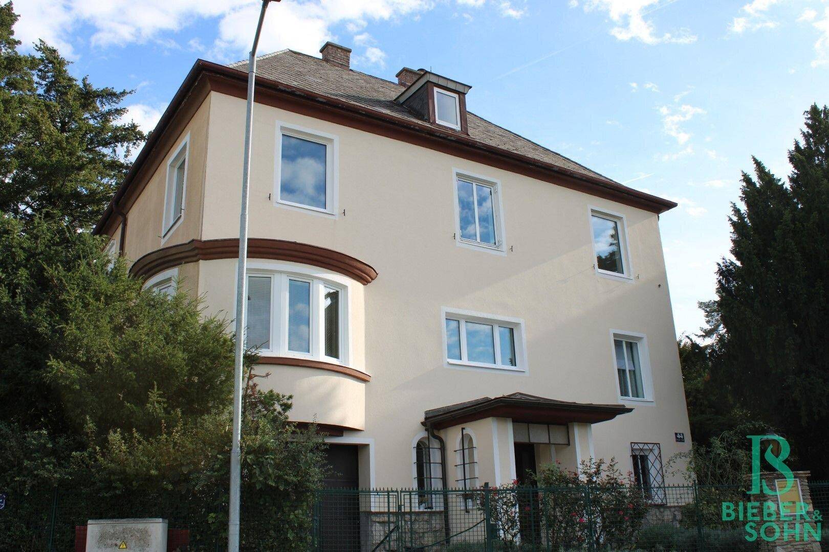Gesamtansicht der Hausfassade mit Erkerfenstern und Eingangsbereich.