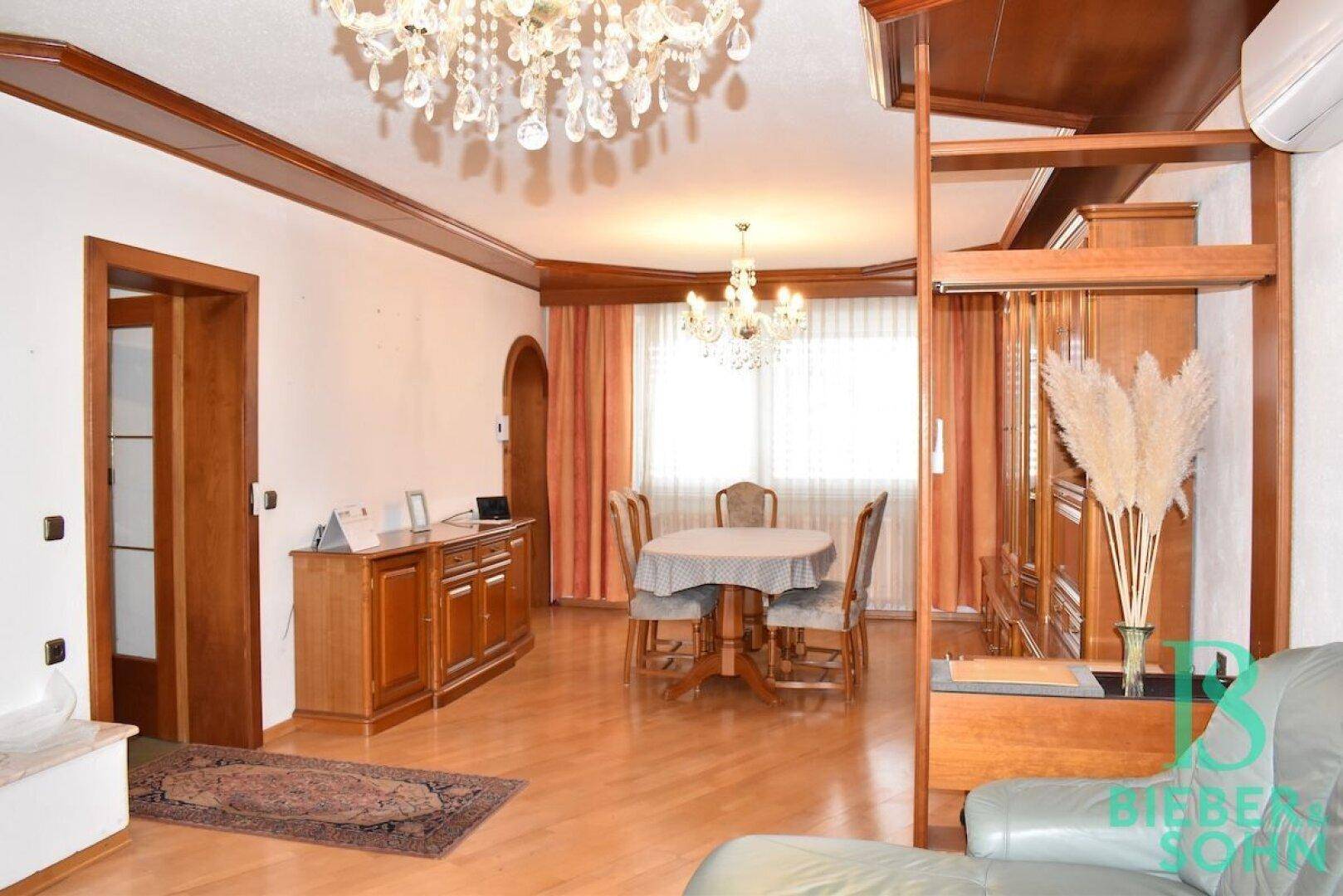 Gemütlicher Essbereich mit rundem Tisch, Stühlen und passenden Holzmöbeln im traditionellen Stil.