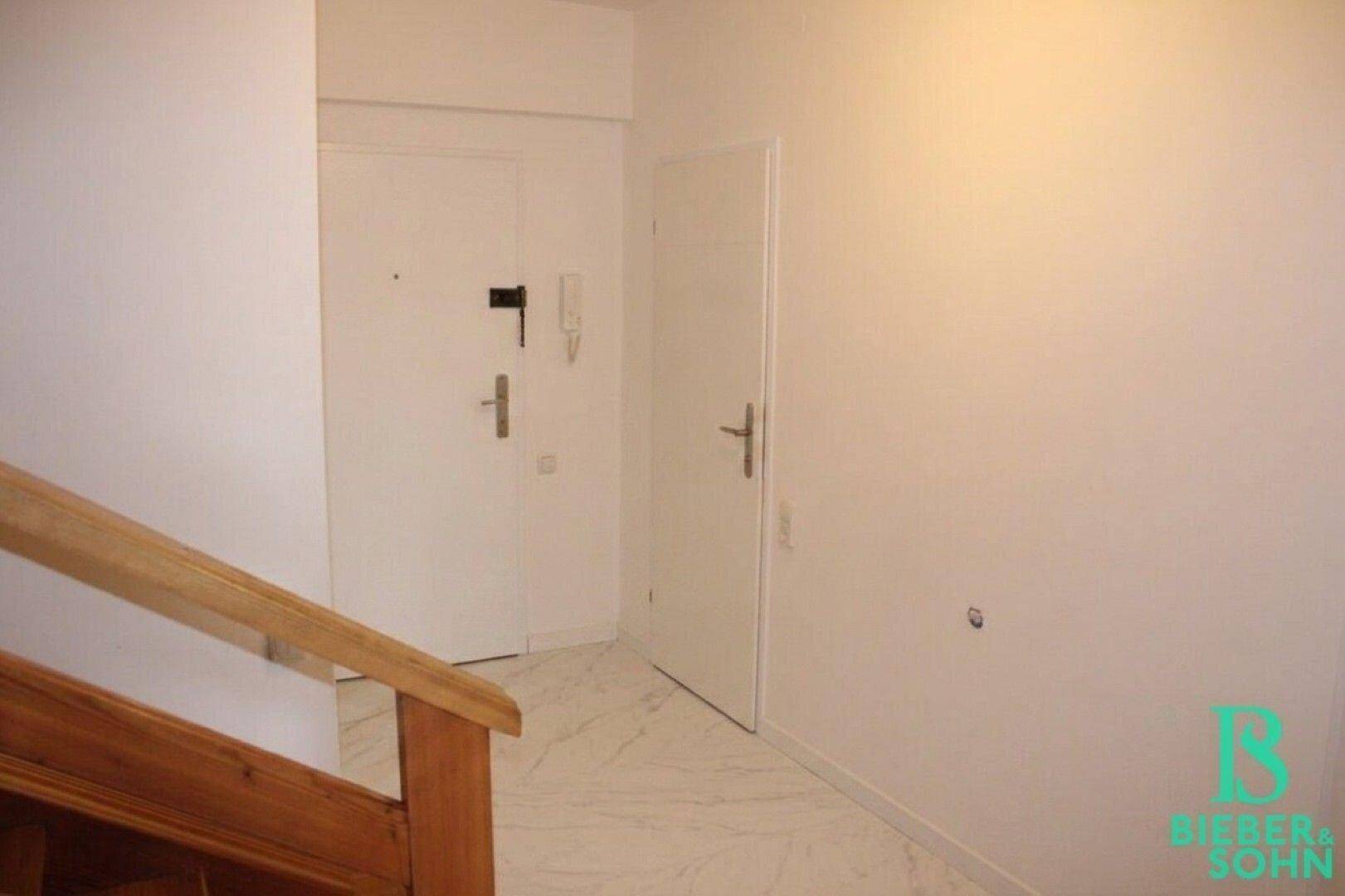 Eingangsbereich mit Haustür, Gegensprechanlage und Fliesenboden.