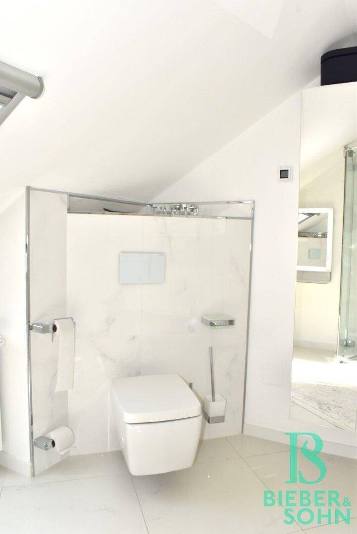 Modernes Wand-WC mit Spülkasten in der Wand und weißen Fliesen im stilvollen Badezimmer.