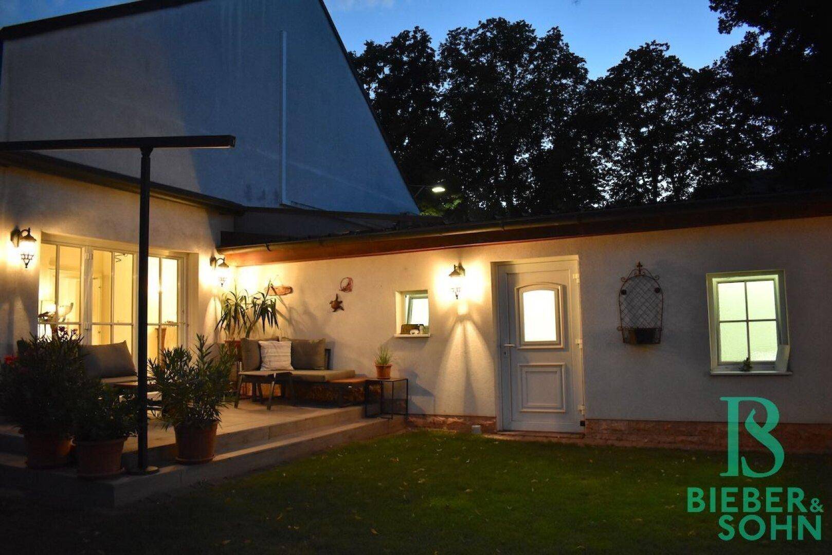 Beleuchteter Garten und Terrasse am Abend, ideal für entspannte Stunden im Freien.