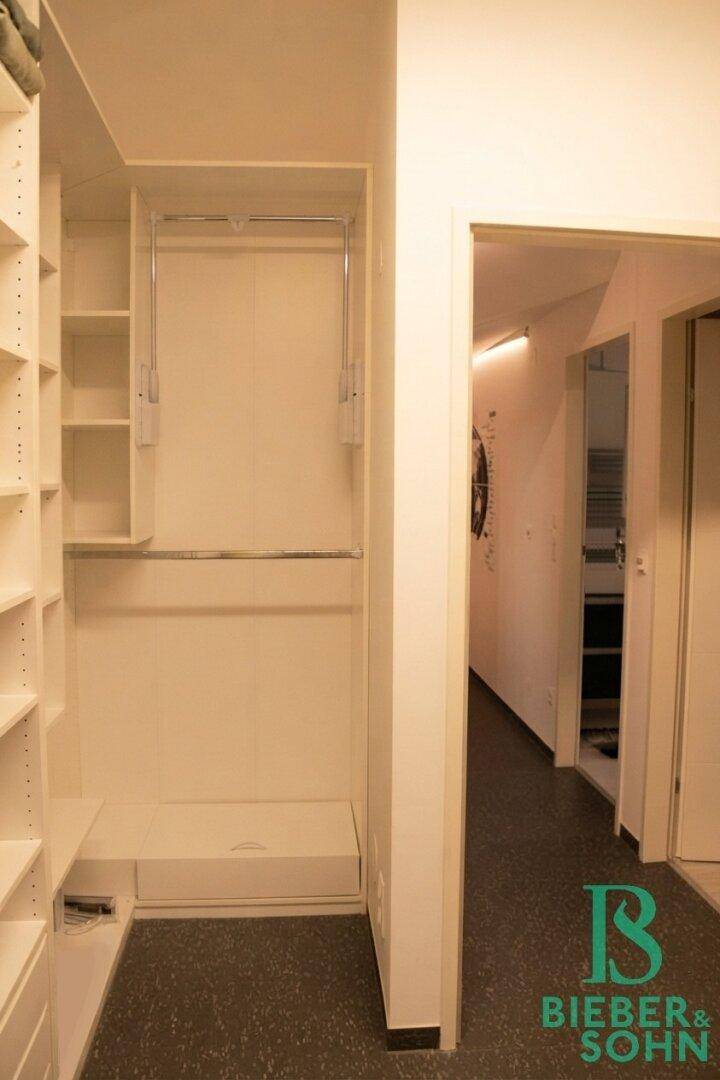 Heller Flur mit integriertem Ankleidebereich und praktischen Regalsystemen.