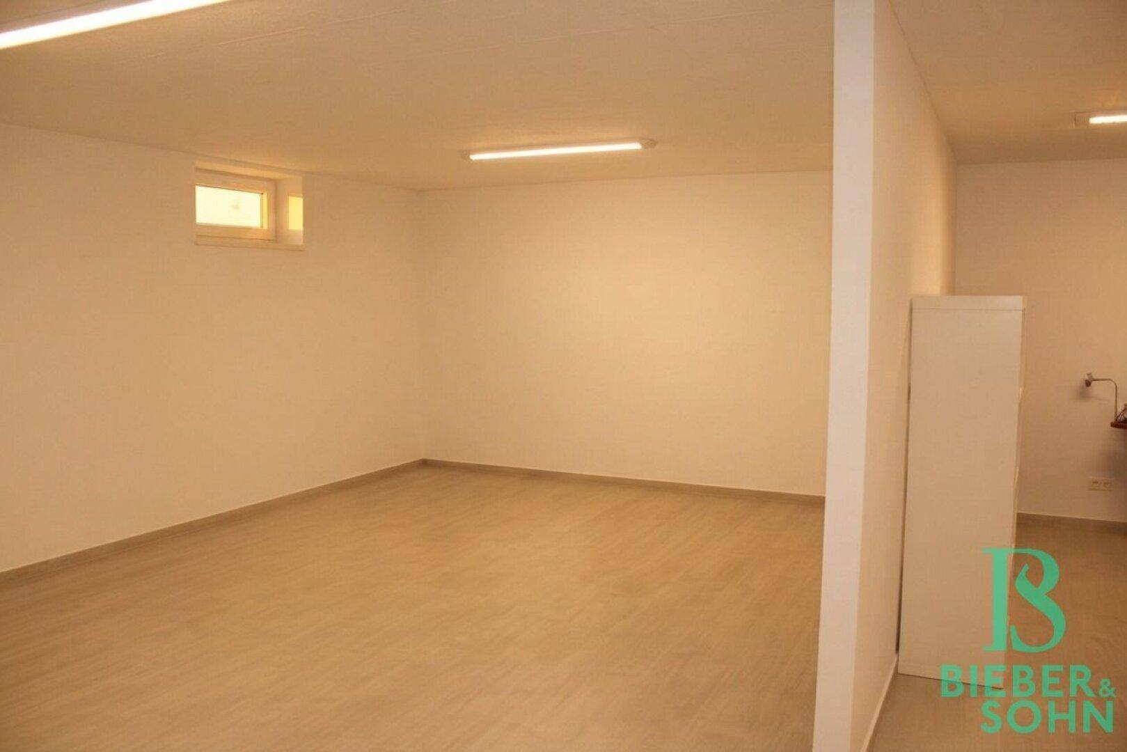 Heller Kellerraum mit praktischer Raumaufteilung und kleinem Fenster für Tageslicht.
