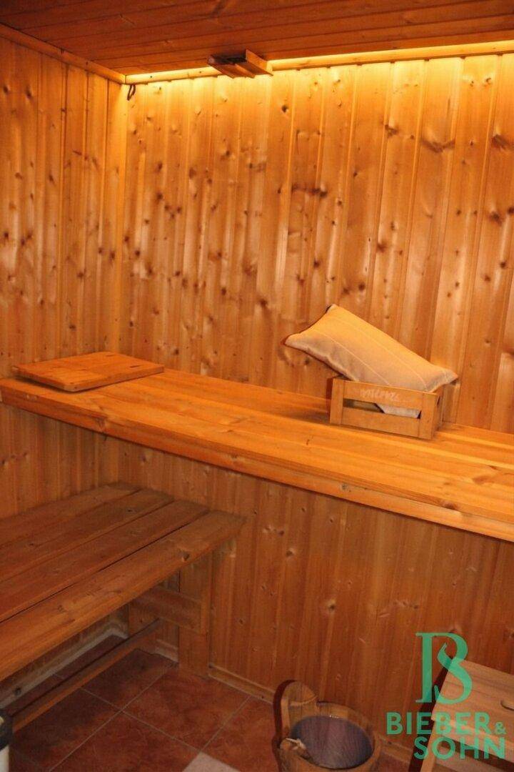 Gemütliche Holzsauna mit bequemen Bänken und stimmungsvoller Beleuchtung für Entspannung.