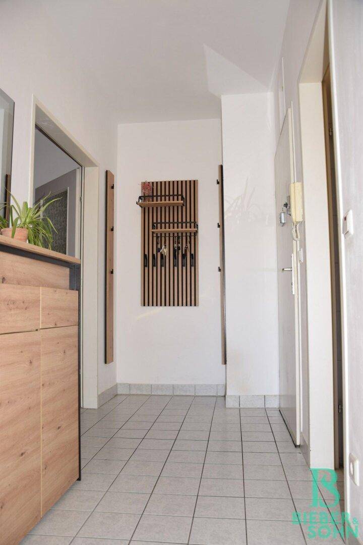 Moderner Flur mit Fliesenboden und praktischer Garderobe, die viel Stauraum bietet.