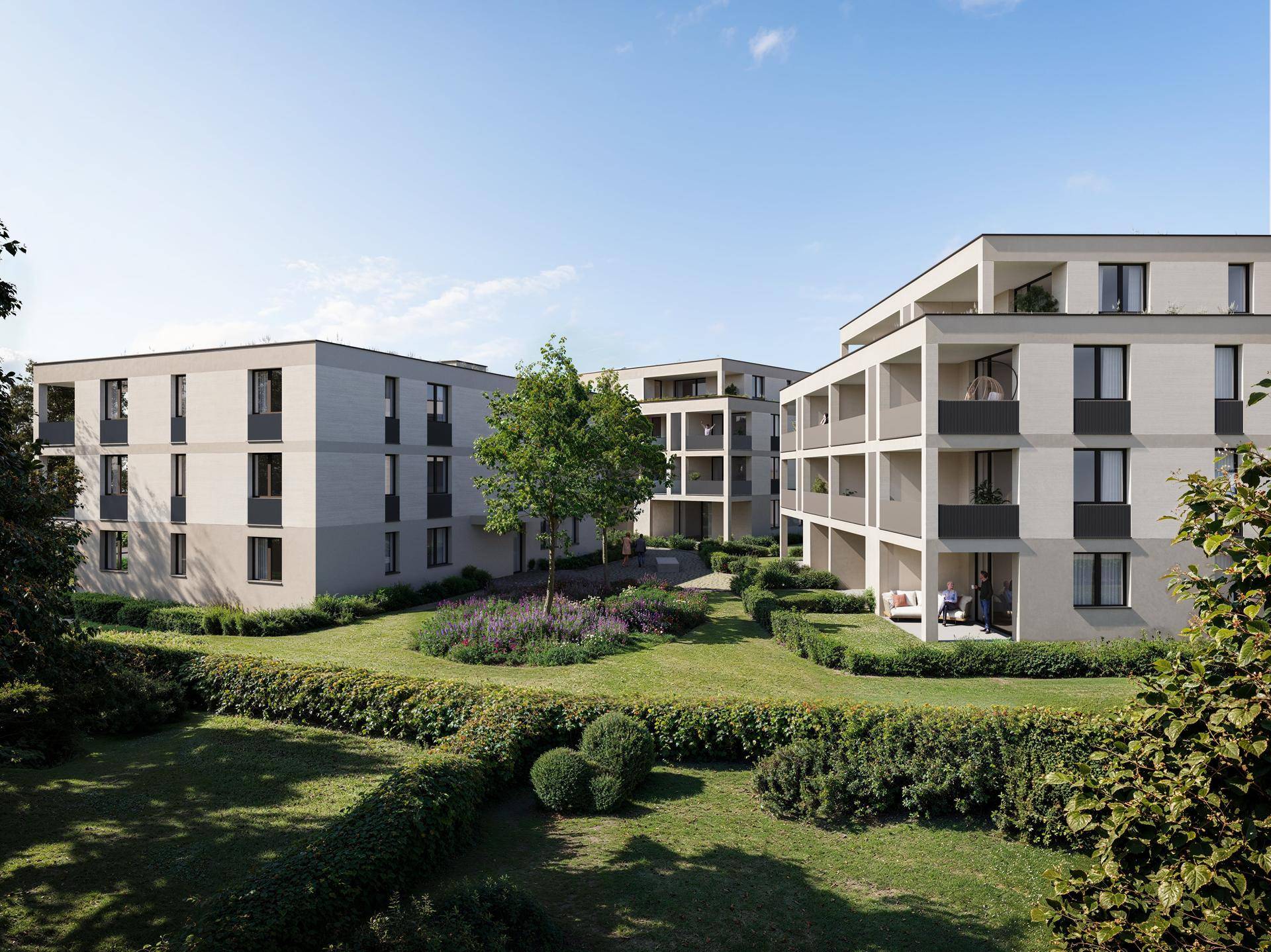 Gepflegte Gartenanlage zwischen modernen Wohngebäuden mit grünen Hecken und Blumenbeeten.
