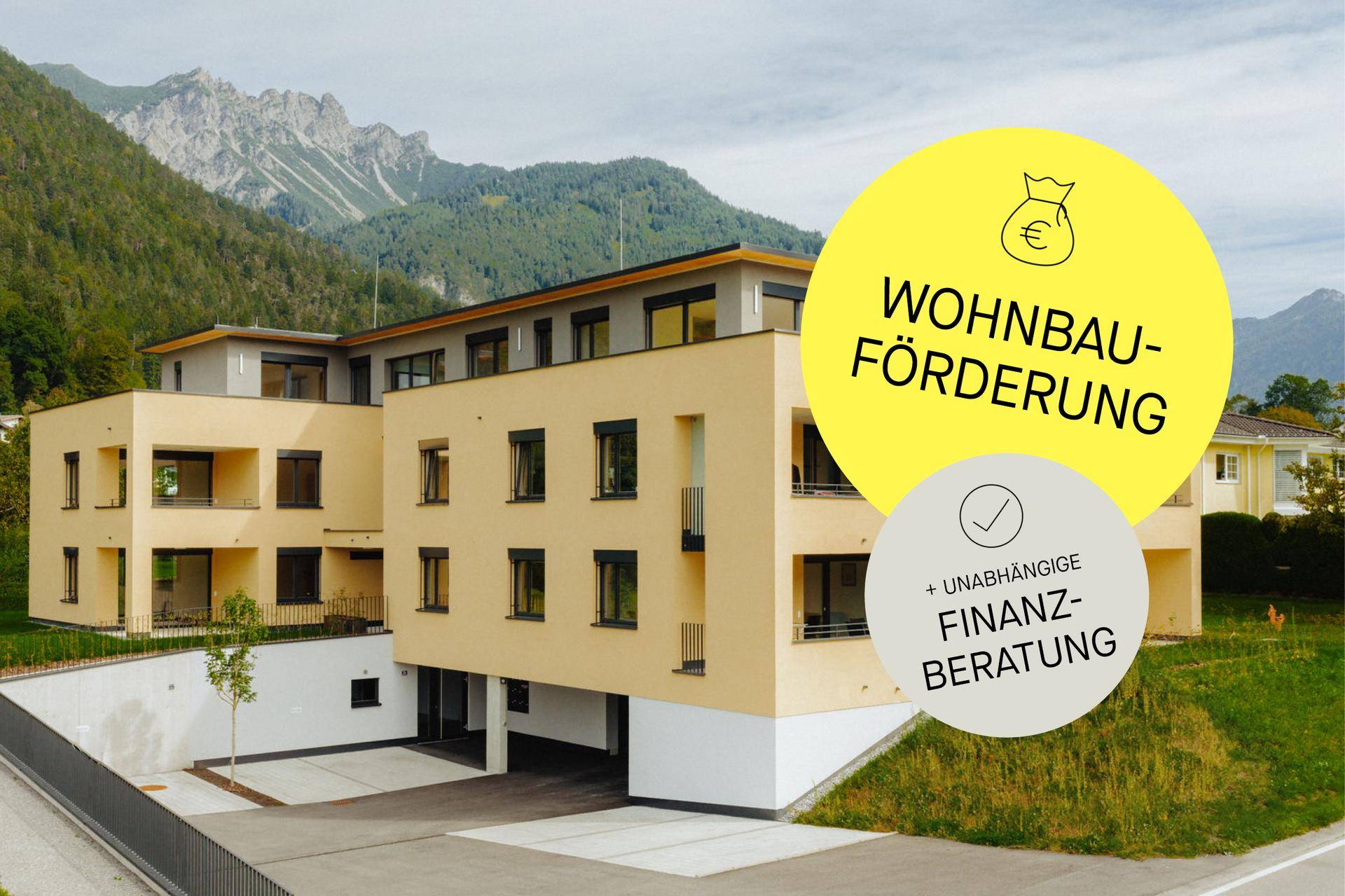 Neubau-Wohnanlage in den Bergen mit moderner Architektur und Hinweisen zur Finanzberatung.