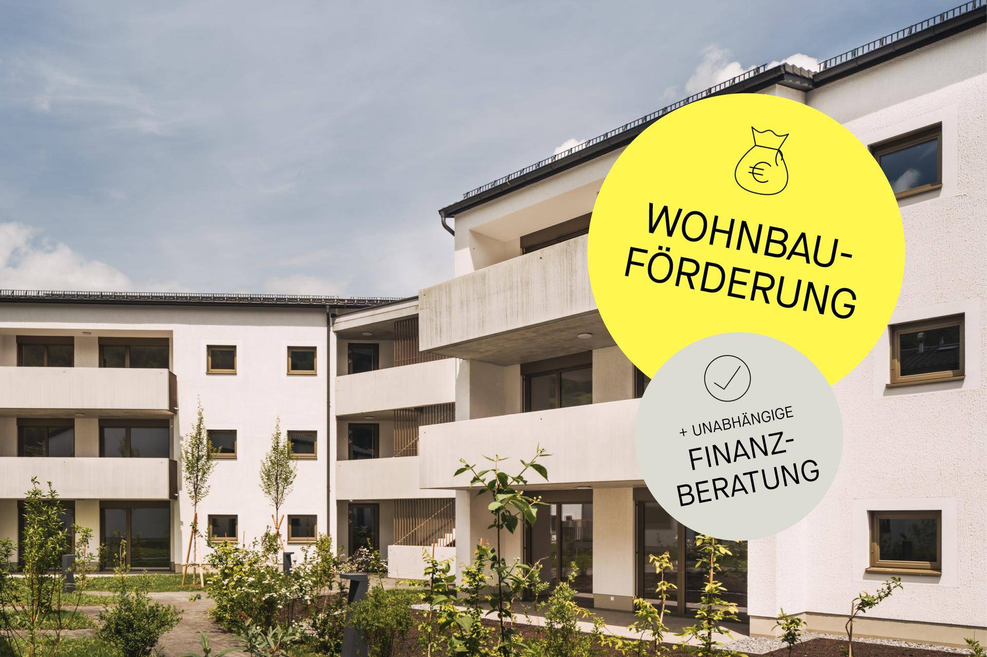 Zeitgenössisches Wohngebäude mit mehreren Balkonen und gepflegter Grünfläche im Vordergrund.