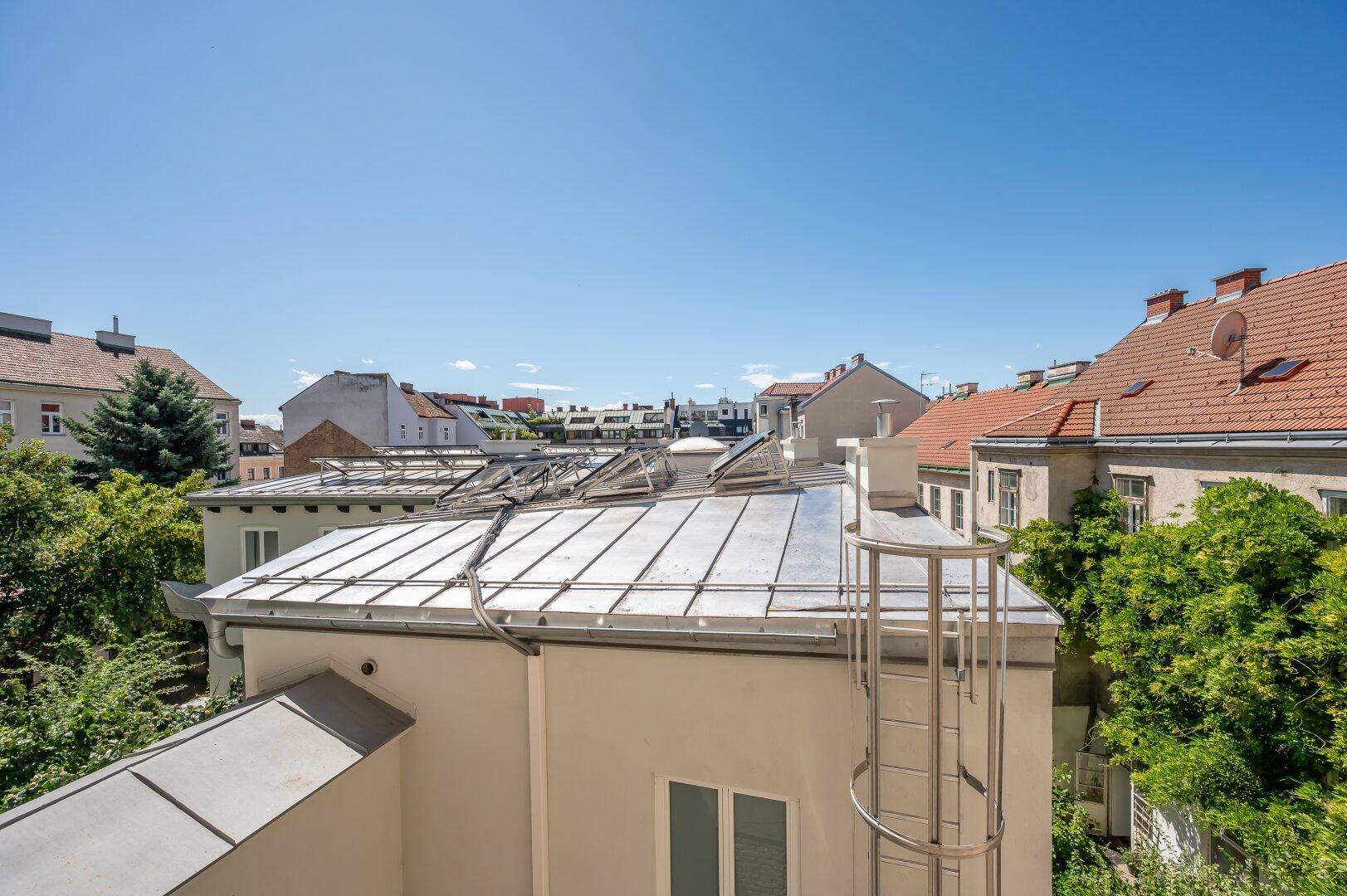 Blick über die Dächer der Stadt mit Solaranlagen und umliegenden Gebäuden.