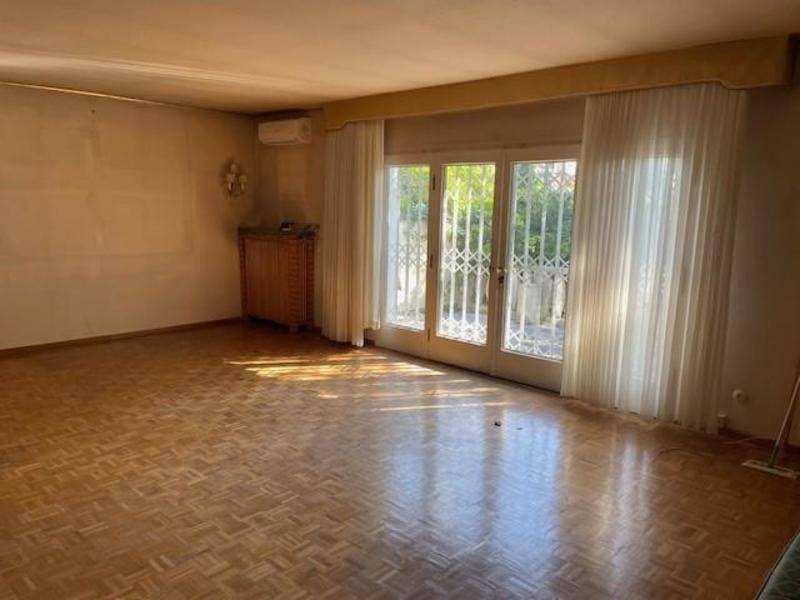 Geräumiges Wohnzimmer mit Parkettboden, großen Fenstern und Zugang zum Garten.