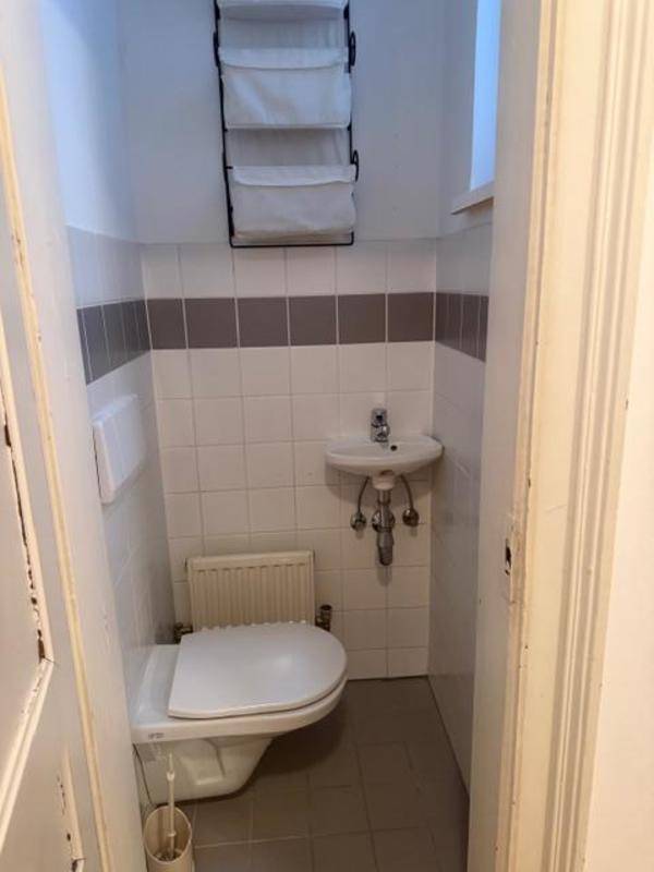 Kleines Gäste-WC mit Toilette, Waschbecken und weißen Fliesen.