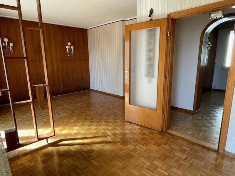 Geräumiger Wohnbereich mit Parkettboden, Holzwänden und dekorativen Wandleuchten.