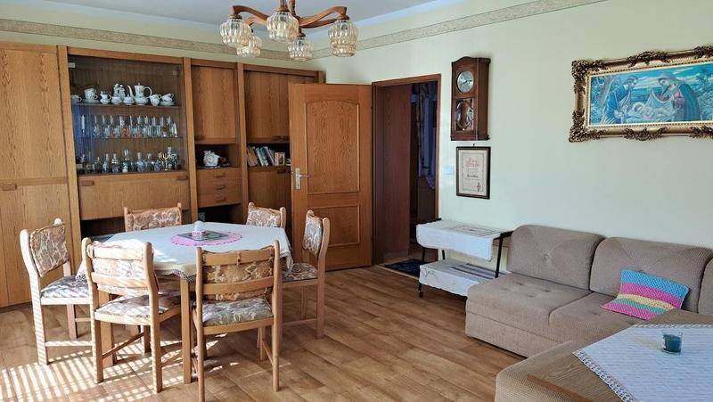 Gemütlicher Wohn-Essbereich mit Holzboden, Esstisch und Sofa, traditionell eingerichtet.
