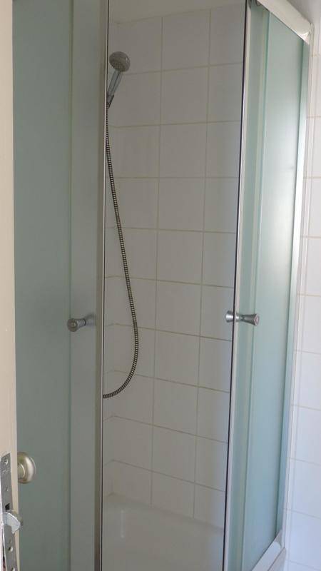 Duschkabine mit Glaswänden und weißen Fliesen im Badezimmer.