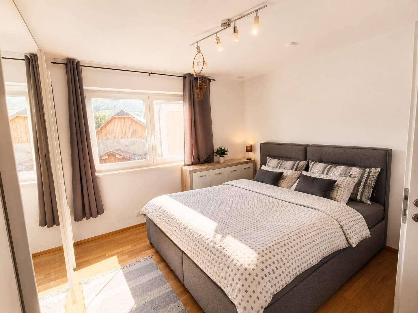 Schlafzimmer mit Doppelbett, Holzboden und einem schönen Blick auf die umliegende Landschaft.