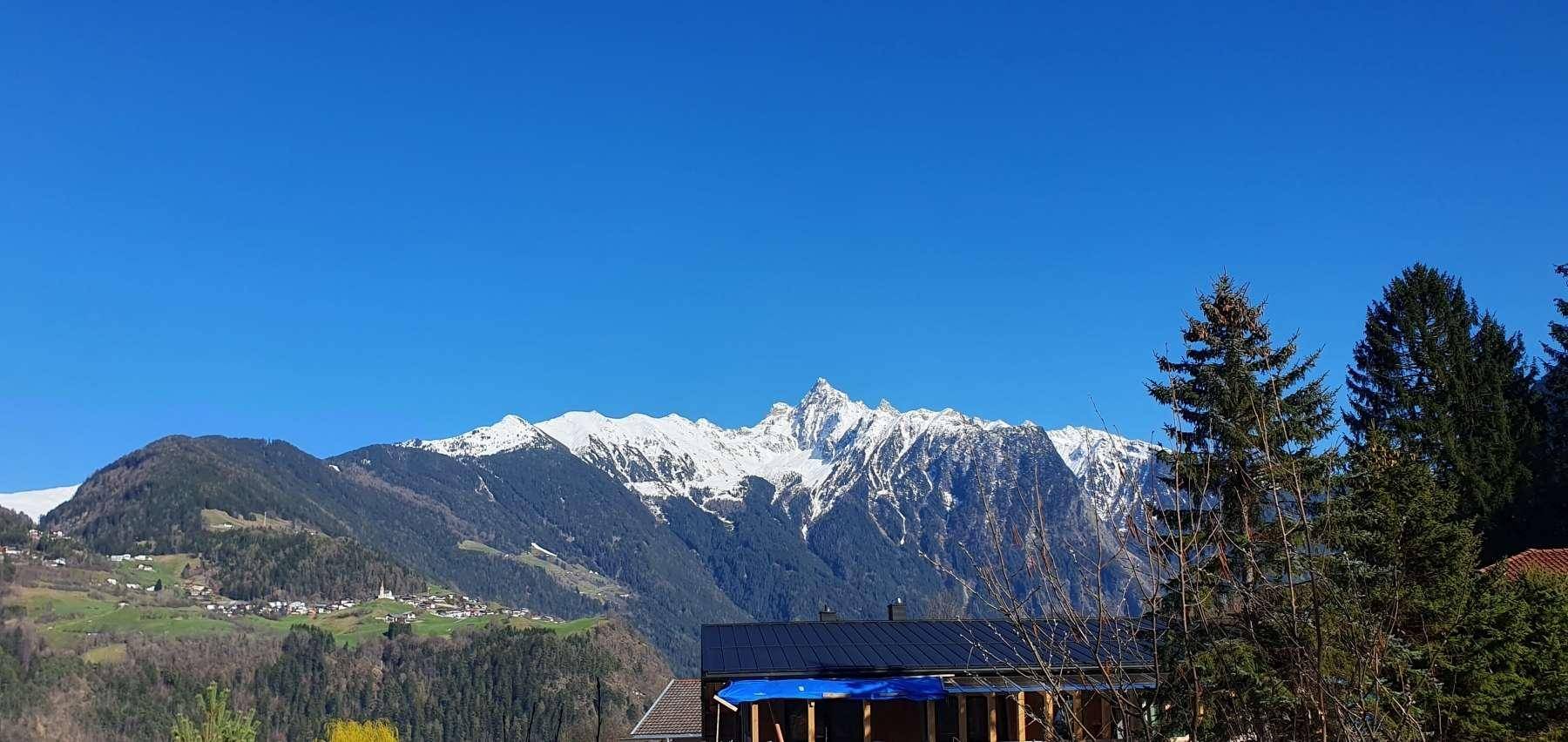 Spektakulärer Panoramablick auf majestätische, schneebedeckte Berge unter einem strahlend blauen Himmel.