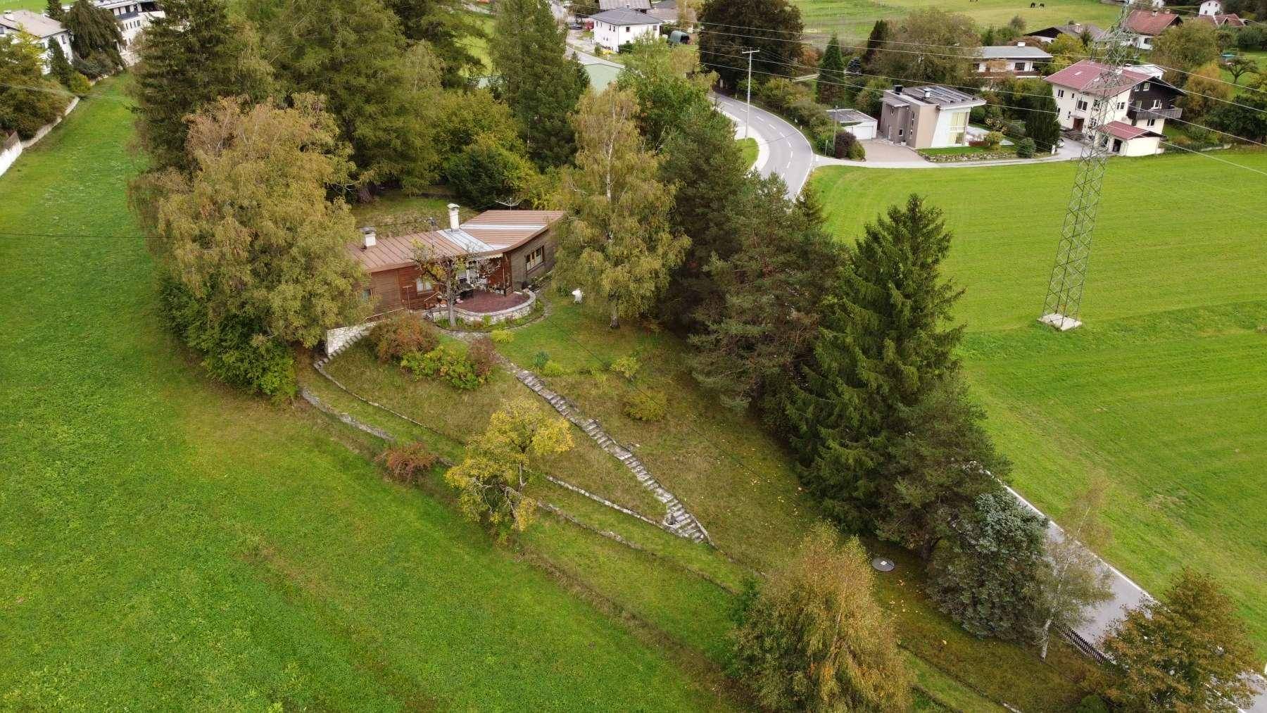Luftaufnahme des Anwesens mit umliegenden Grünflächen, Wald und einer Straße in der Nähe.