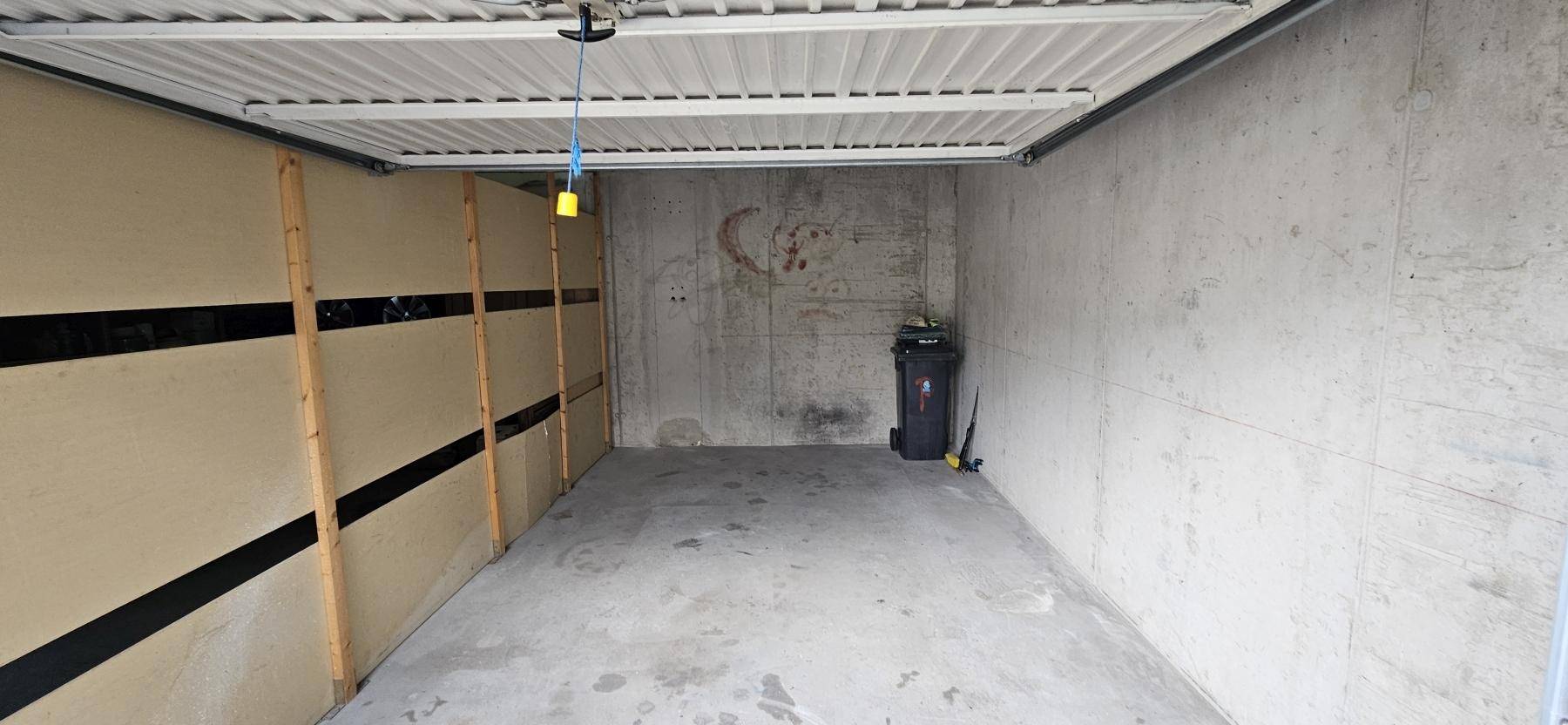 Geräumige Garage mit Betonboden und einfacher Ausstattung, bietet Platz für ein Fahrzeug.