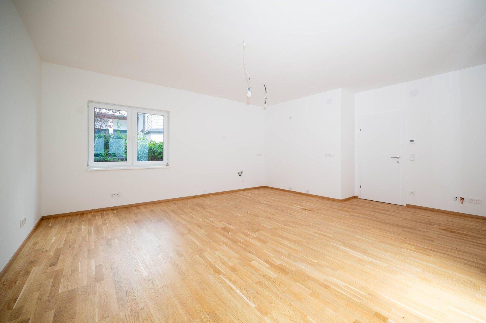 Wohn-/Esszimmer mit offener Küche und Zugang zur Terrasse