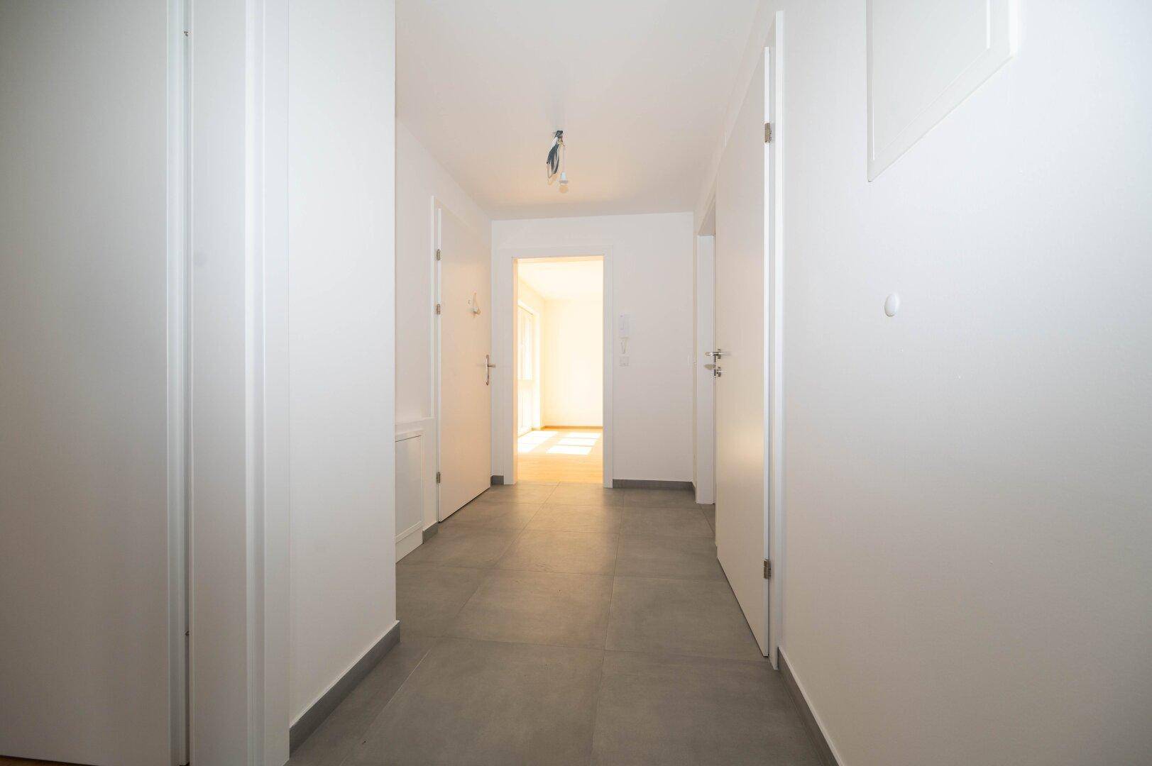Geräumiger Eingangsbereich mit Fliesenboden und Zugang zu verschiedenen Zimmern der Wohnung.
