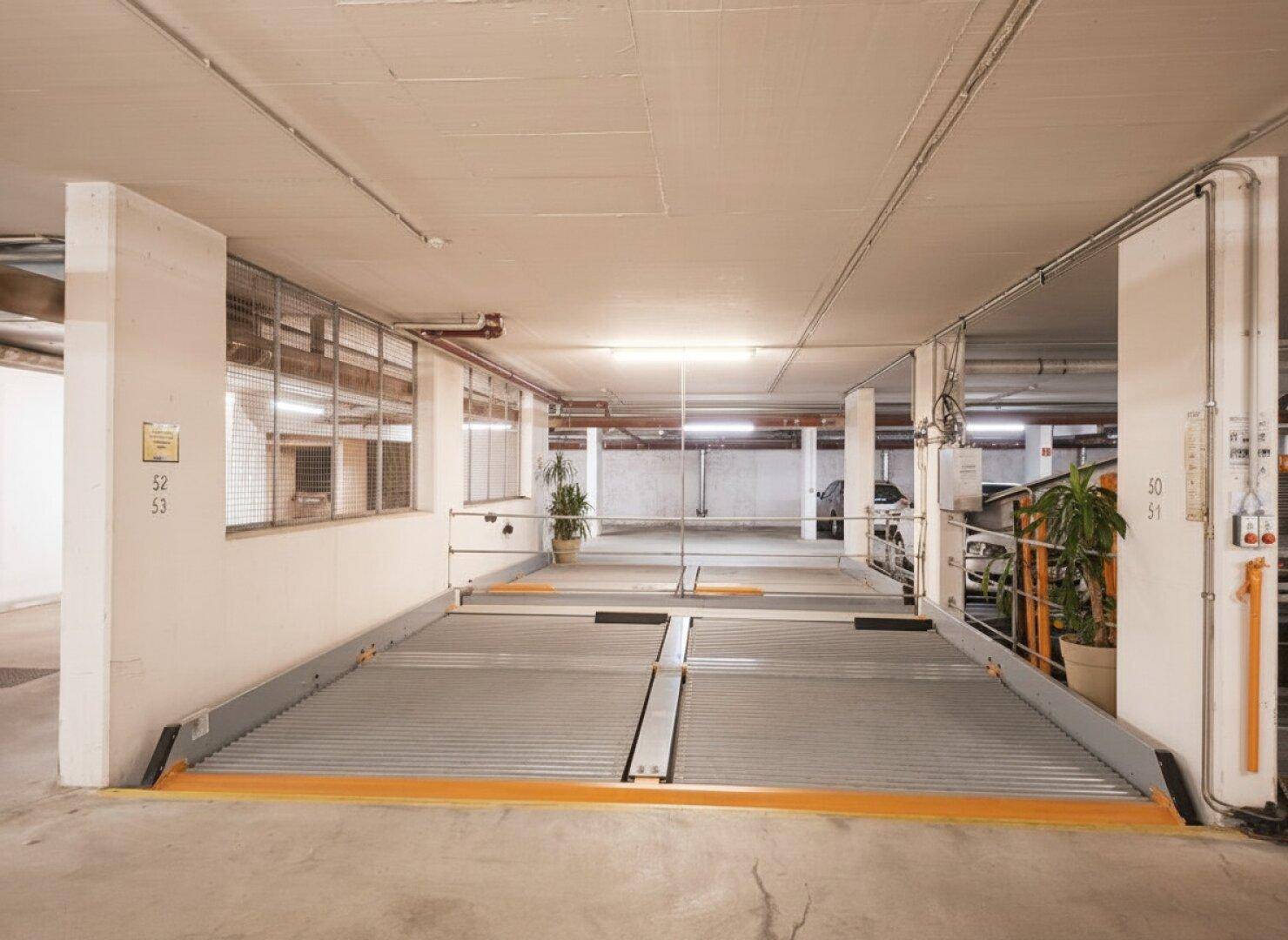 Leeres Doppelparker-System in einer Tiefgarage, bereit zur Aufnahme weiterer Fahrzeuge.