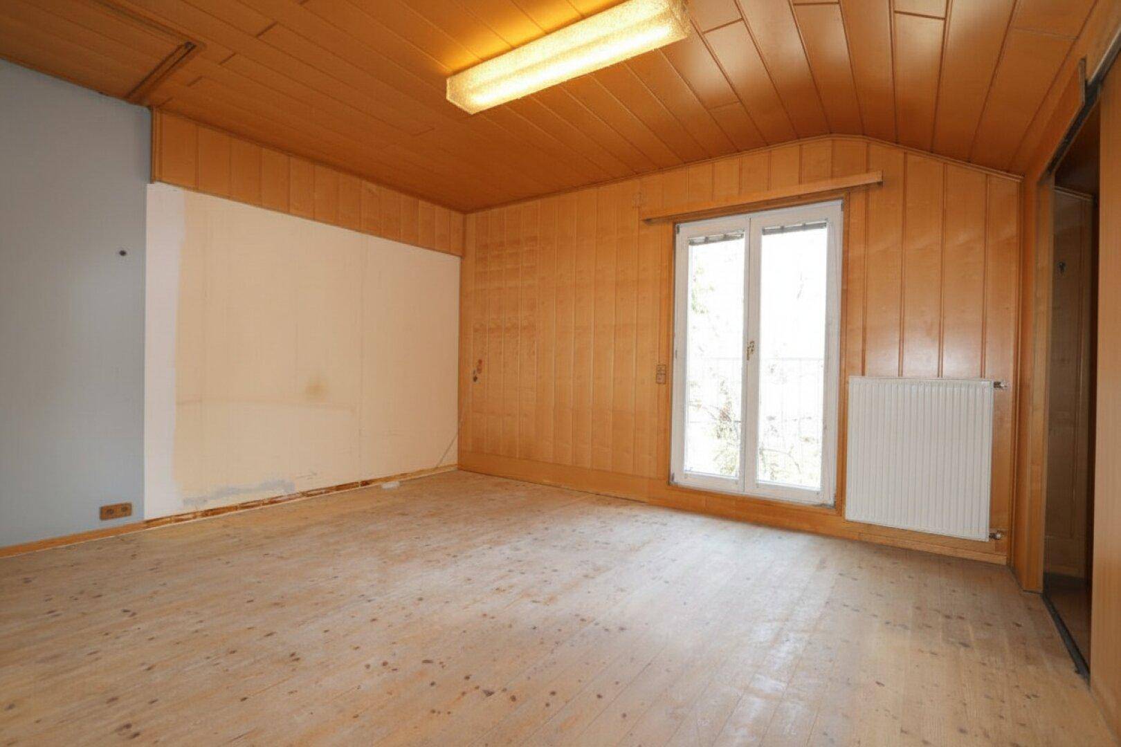 Raum mit Holzverkleidung und Holzboden, bietet eine gemütliche Atmosphäre.