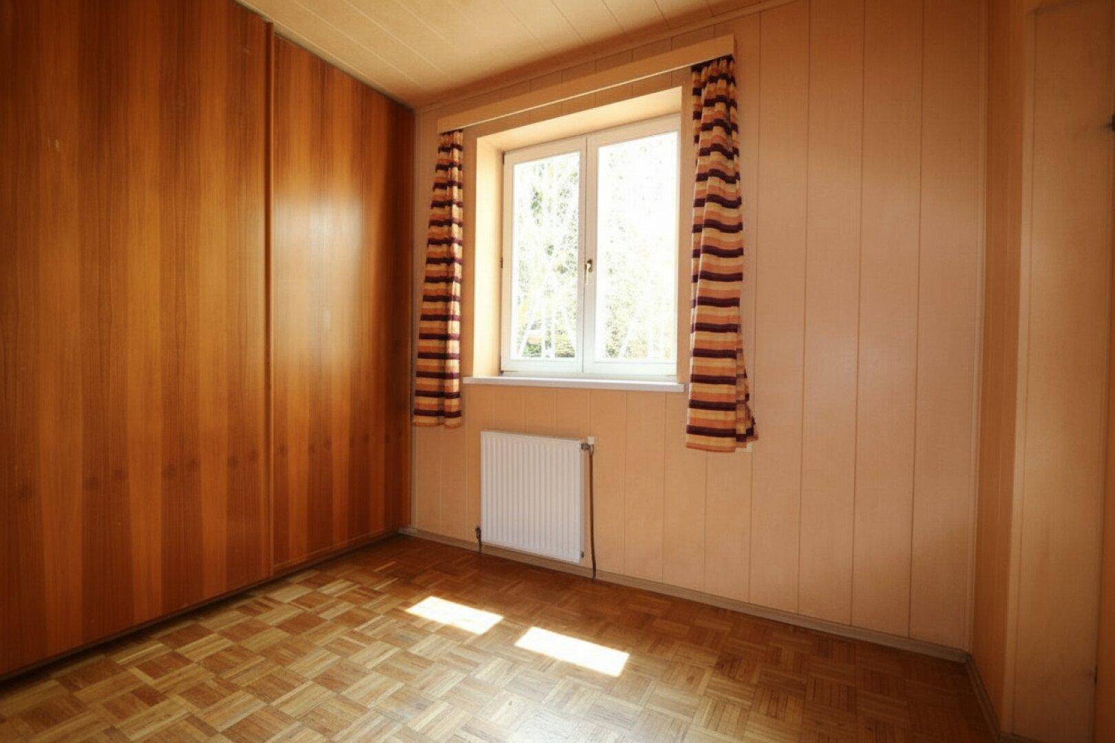 Schlafzimmer mit Parkettboden und großen Einbauschränken, bietet viel Stauraum.