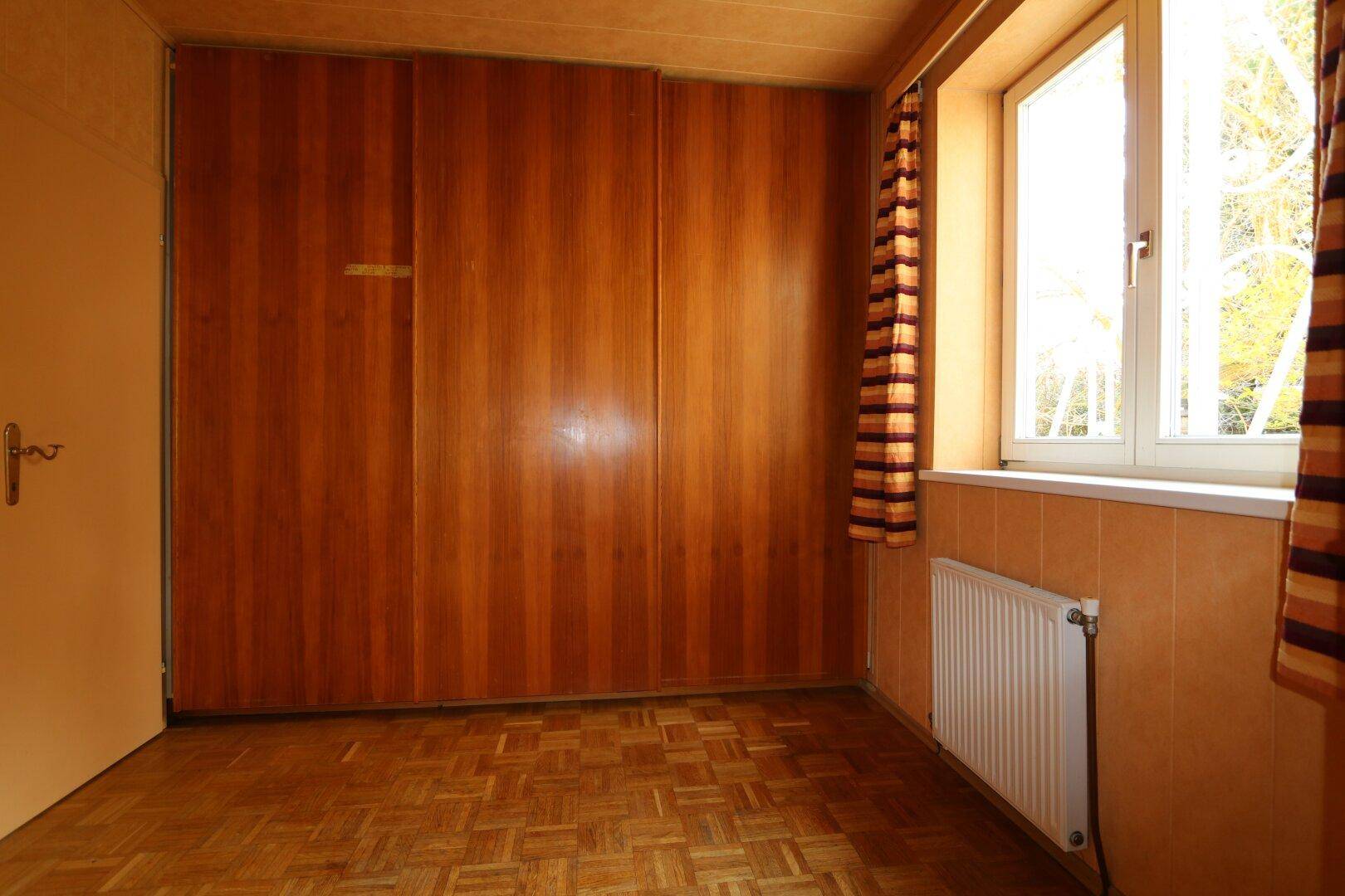 Schlafzimmer mit Holzboden und großen Einbauschränken, bietet viel Platz.