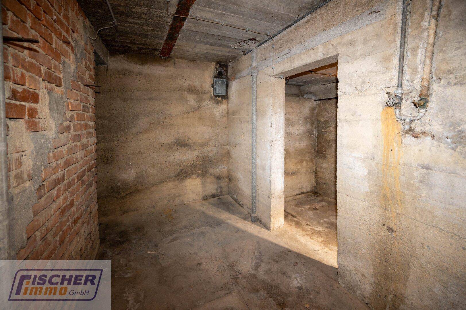 Unausgebauter Kellerraum mit Ziegelwand und Betonboden.