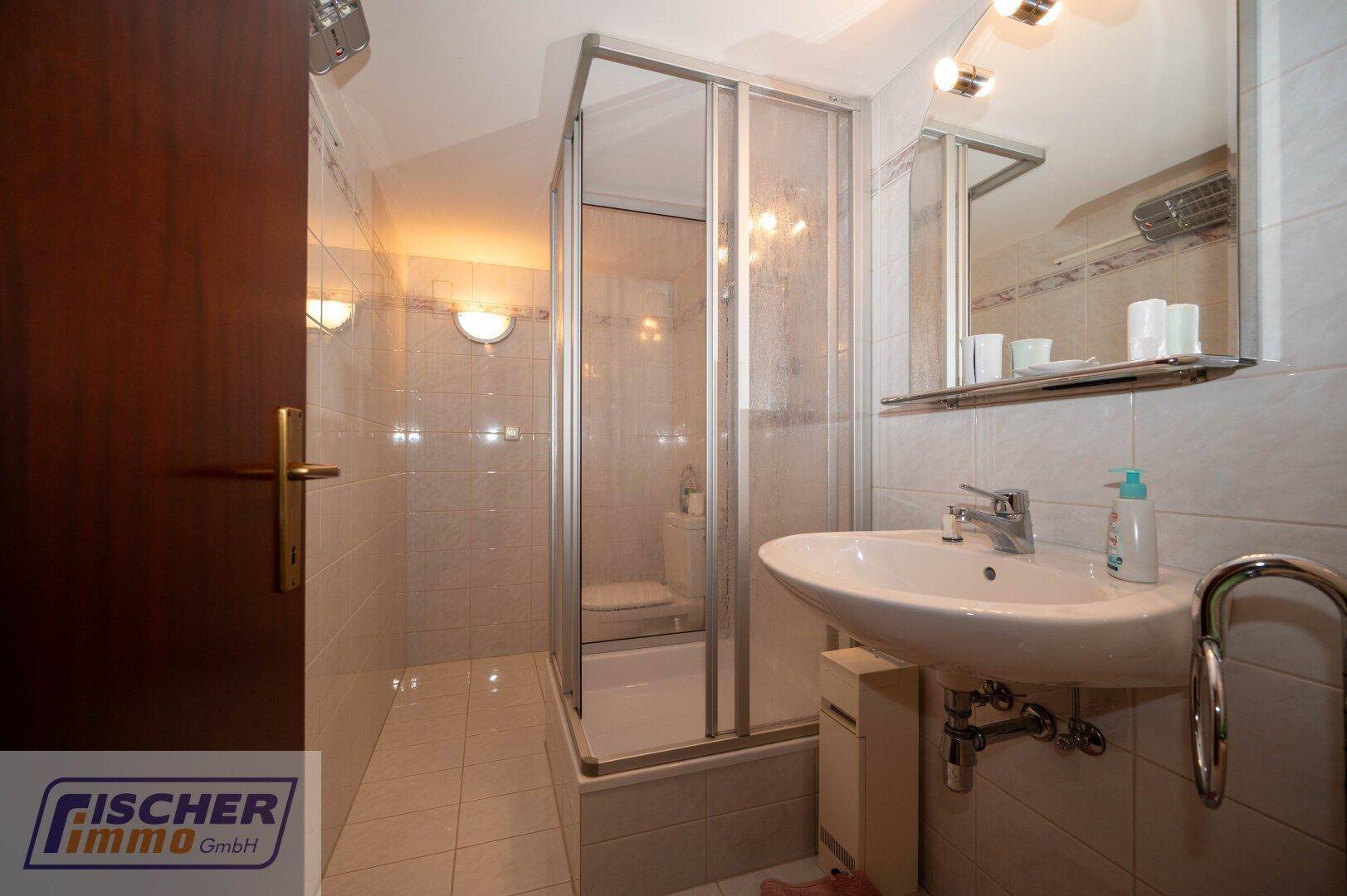 Kleines Badezimmer im Untergeschoss mit Dusche und Waschbecken.