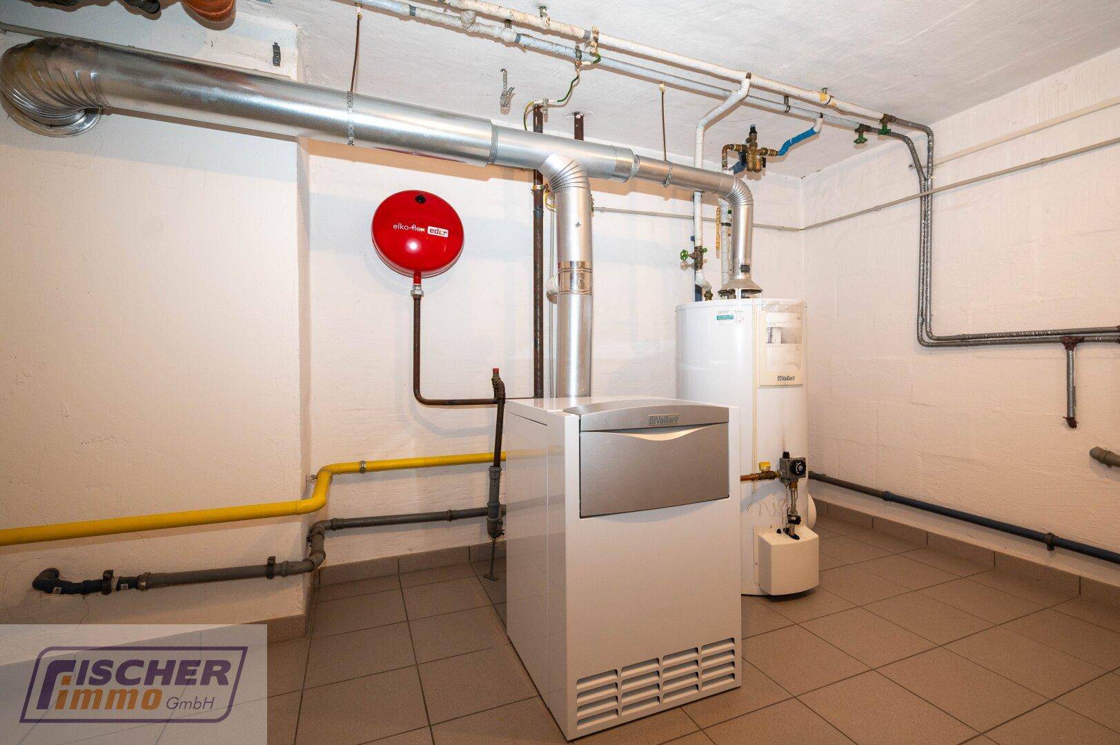 Heizungsraum im Keller mit moderner Heizungsanlage und Rohrleitungen.