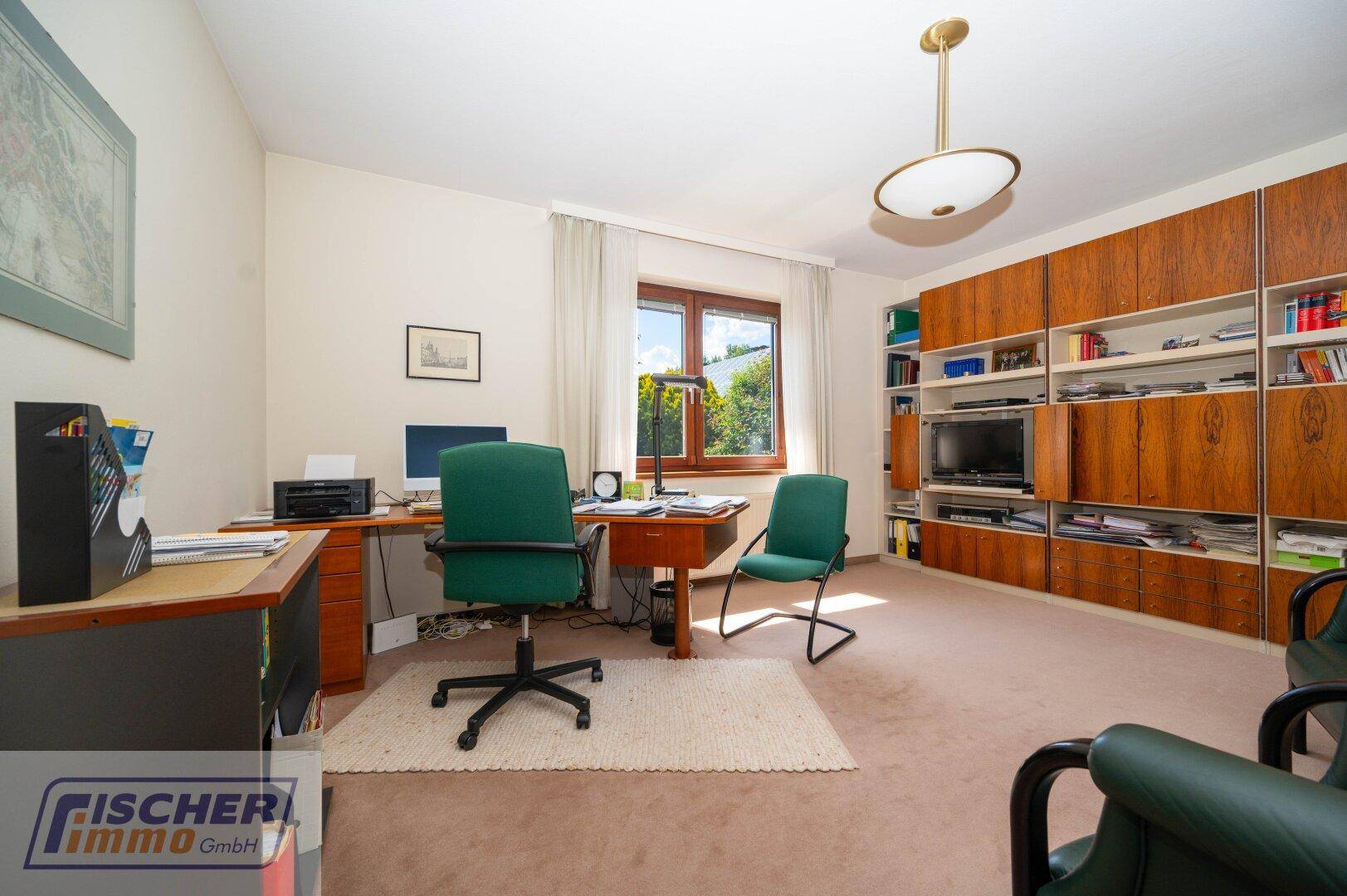 Geräumiges Arbeitszimmer mit Schreibtisch, Bürostuhl und integrierten Regalen.