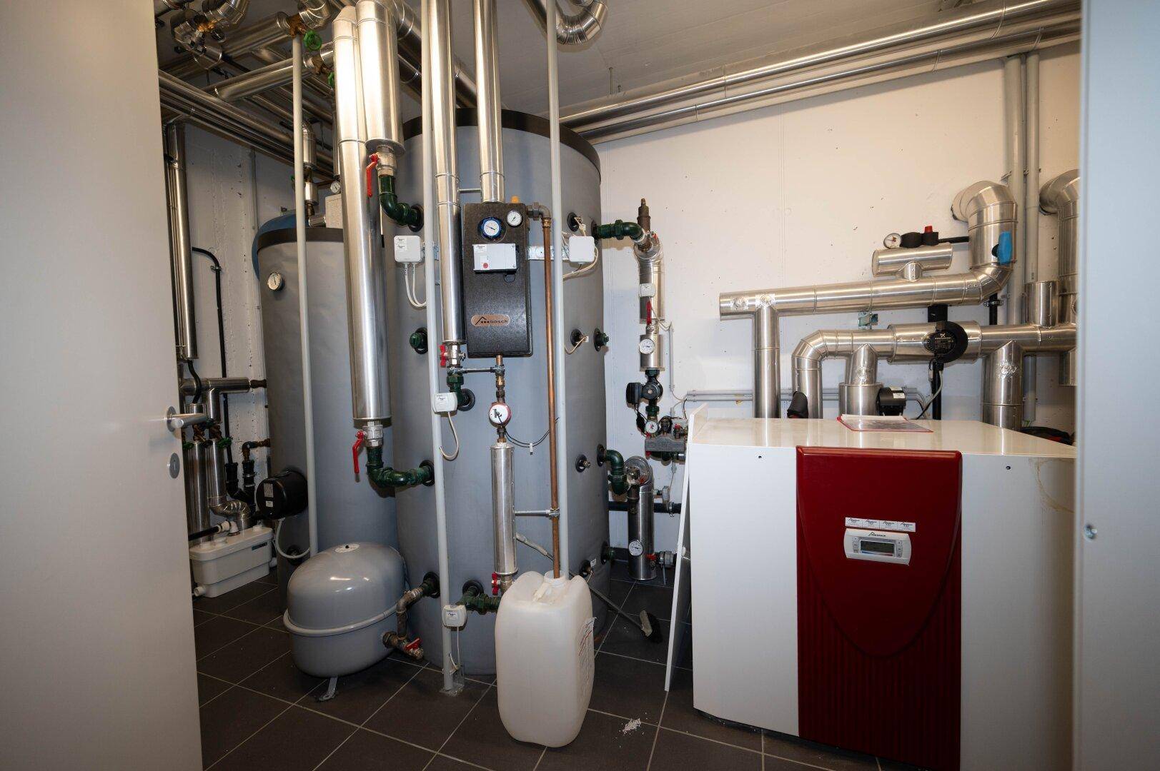 Heizungsraum mit modernen Anlagen und zahlreichen Rohren für die Gebäudetechnik.