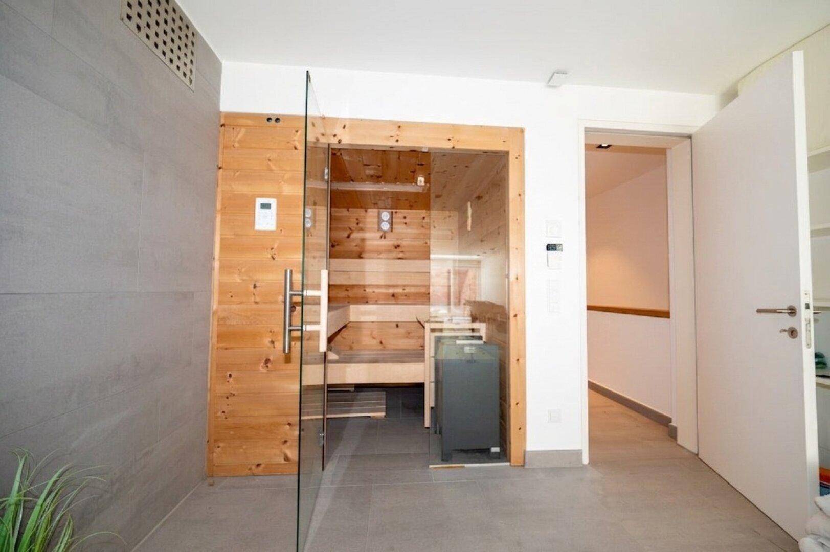 Private Sauna mit Holzbänken und Glastür, ideal zur Entspannung und Wellness.