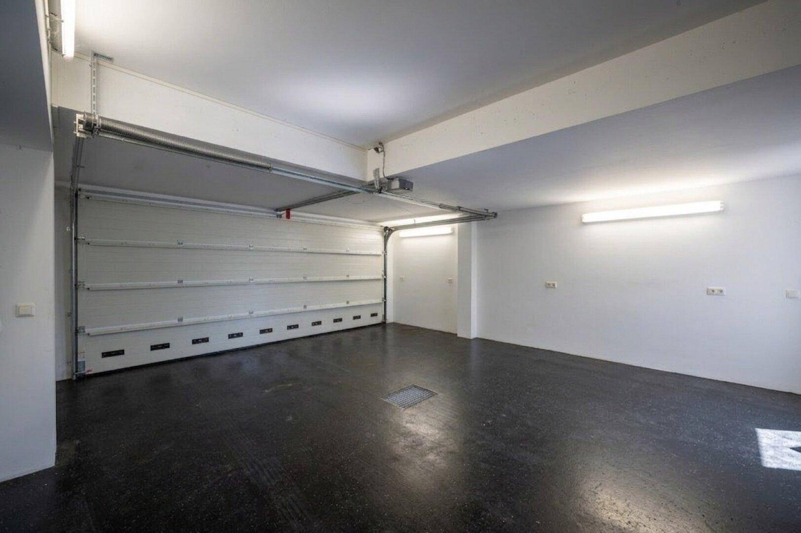 Geräumige Garage mit offenem Tor und viel Platz für Fahrzeuge.