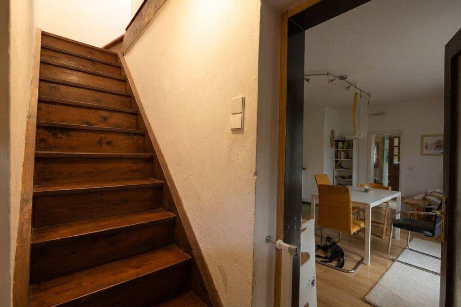 Rustikale Holztreppe führt in die obere Etage, mit Blick auf den Wohnbereich.
