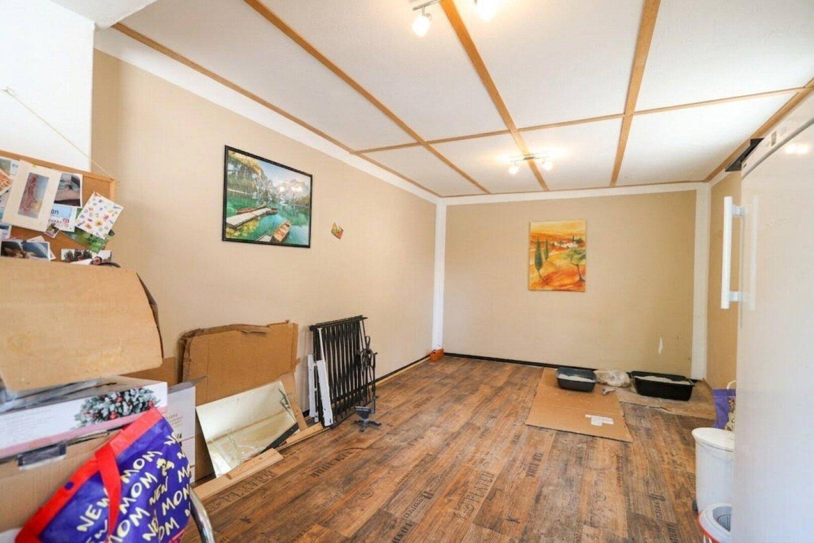 Geräumiger Raum mit Holzbalkendecke und Holzfußboden, bereit zur individuellen Gestaltung.