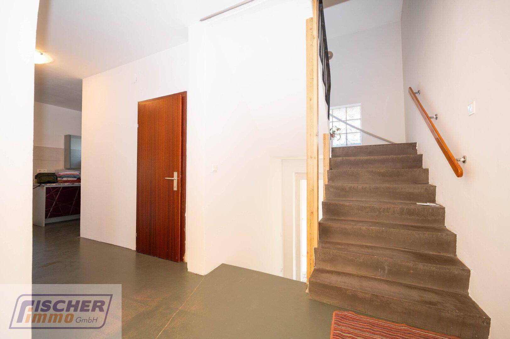 Treppenhaus mit Holzstufen und Handlauf, führt zu den oberen Etagen.